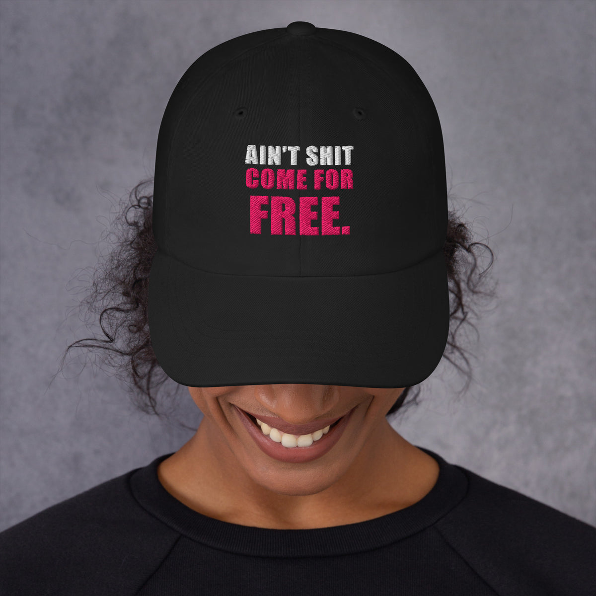 Model wearing black Ain't Shit Come for Free embroidered cap, front view